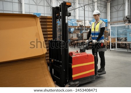 Caucasian businessman or foreman worker checking Kraft paper stock with forklift background at warehouse