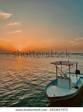 A boat resting in ocean under sunset 