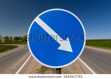 a blue car sign with a white arrow , a car sign indicating the direction of traffic to the right