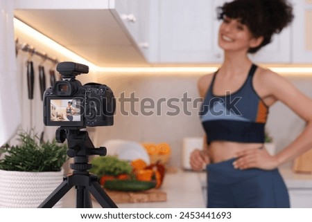 Food blogger explaining something while recording video in kitchen, focus on camera Royalty-Free Stock Photo #2453441693