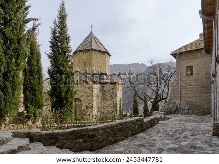 Church inside of Ateni nunnery.  Cypress trees. Stone courtyard. Autumn colors. Georgia.
