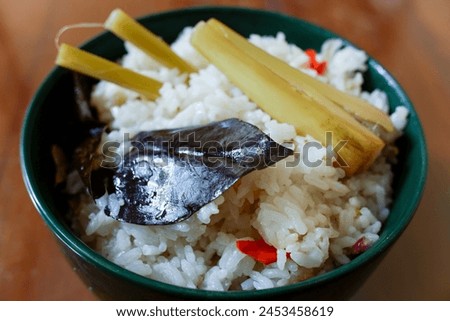 A bowl of Sundanese liwet rice with spices, in the wood table, traditional Indonesian food, stock photo.