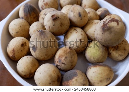 Duku fruit in a white plate, tropical fruit stock photo.