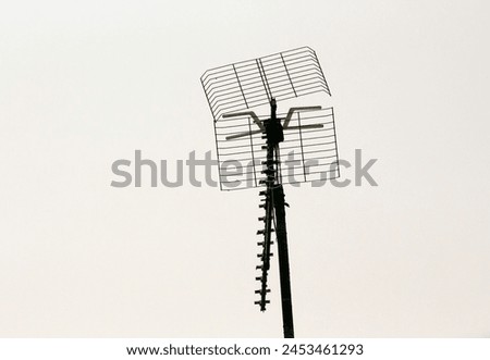 TV antenna on a pole against cloudy sky