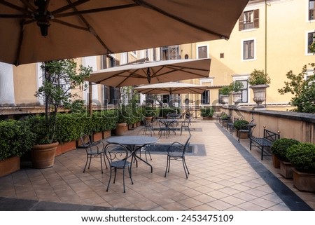 Details from the sumptuous and rich exterior of the Palazzo Colonna in Rome, Italy. Beautifully furnished and cosy place for rest and coffee with lots of plants. Royalty-Free Stock Photo #2453475109