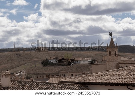 rustic village under a cloudy sky, highlighting architecture, nature's beauty, and a serene, historical atmosphere