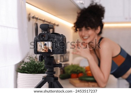 Food blogger explaining something while recording video in kitchen, focus on camera Royalty-Free Stock Photo #2453517237