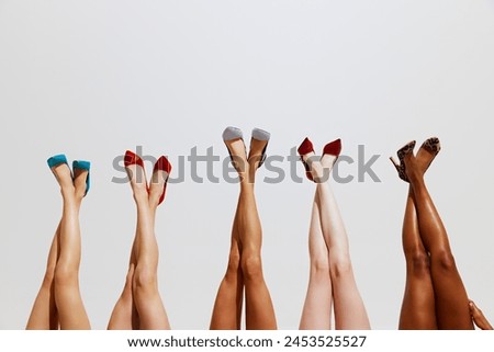 Cropped photo of slim female legs with different skin tones in different stylish high heels against white studio background. Concept of beauty, spa procedures, cosmetology, dieting. Ad