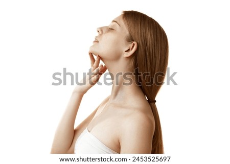 Side view photo of young woman massaging her neck and chin to prevent double chin against white studio background. Concept of natural beauty, organic cosmetic, spa procedures, face-care.