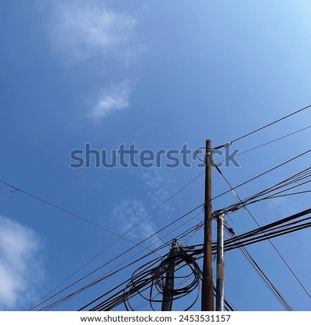 Margaasih - Bandung, West Java. Arrangement of cables and electricity poles under a clear blue sky.