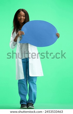 Female doctor, on a green background, full-length, with a blue comment mark