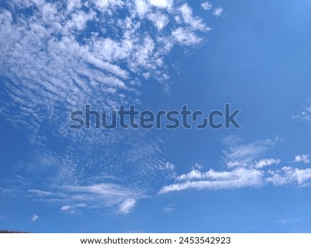 White clouds, like cotton, blue sky, blowing wind, sunny weather, beautiful nature in the sky Royalty-Free Stock Photo #2453542923
