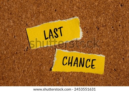 Last chance words written on ripped yellow paper pieces with brown background. Conceptual last chance symbol. Copy space.