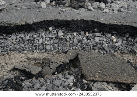 Asphalt road cross section in repair and reconstruction work. To show layer of surface and underground material. asphalt concrete, bitumen, soil, sand, rock, stone, crust, ground and earth. earthquake Royalty-Free Stock Photo #2453552375