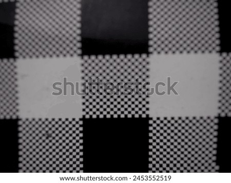 The checkered background is black and white and taken with a blurry photo