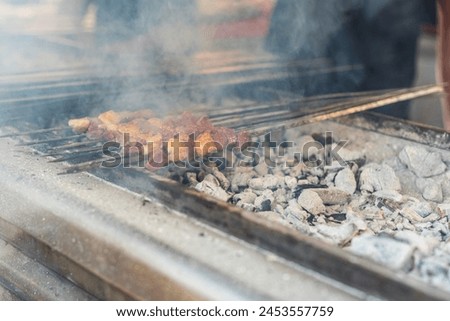 Traditional meat called 'ciger' made by liver on a bbq with smokes in The orange blossom festival in the city of Adana, close up, outdoor photography	