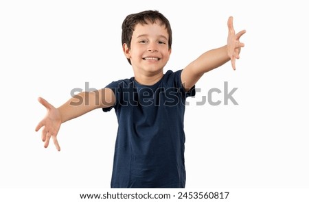 Child wearing summer t-shirt over isolated white background looking at the camera smiling with open arms for hug. Cheerful expression embracing happiness. Royalty-Free Stock Photo #2453560817