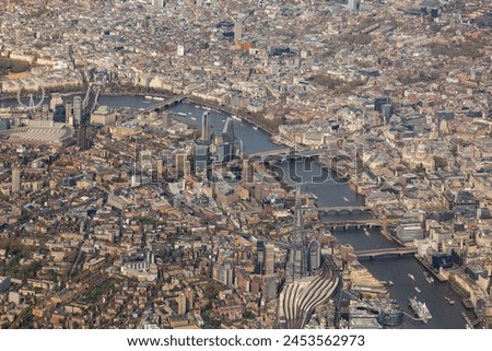 High aerial view of downtown city of London, with river Thames, the Shard, Tower bridge, HMS Belfast and may buildings, squares, offices. Taken from airplane