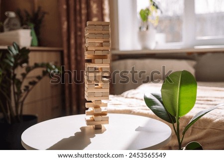 Wooden blocks table game under sunlight on a white table in a room opposite the window.