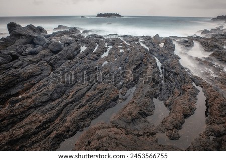 Long exposure picture of volcanic coastline during cloudy day