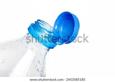 Close up of new cap attached to plastic bottle, connected to the neck of the bottle by solid tab attached to safety ring. They are intended to encourage recycling, as part of the fight against litter. Royalty-Free Stock Photo #2453585185