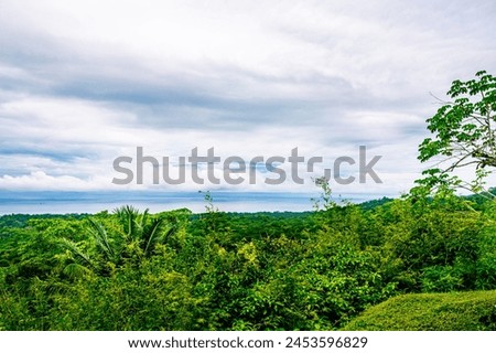 Expansive tropical vista with a cloudy sky merging into a calm sea, showcasing nature tranquility. High Quality Photo. Costa Rica, Pacific Coast