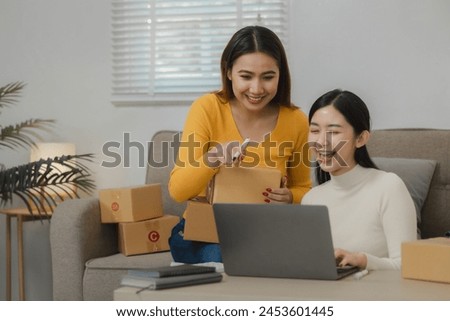 Two business owners are checking customer information on a package before it is delivered to the buyer, Two co-workers are checking that order data matches sales figures. Royalty-Free Stock Photo #2453601445