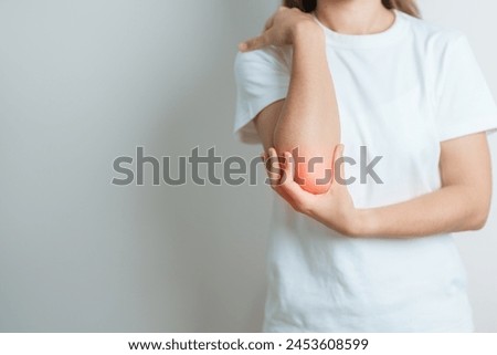 Woman having elbow ache at home, muscle pain due to lateral epicondylitis or tennis elbow. injury, Health and medical concept Royalty-Free Stock Photo #2453608599