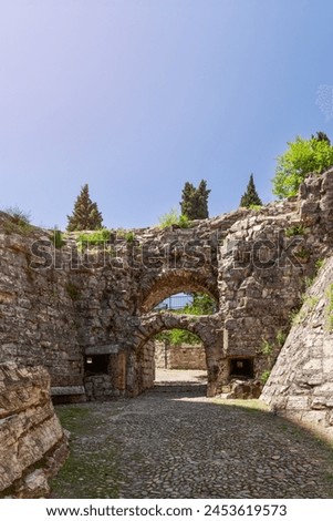 Time worn arches crown the entrance to Brescia castle from Strada del Soccorso. Italy Royalty-Free Stock Photo #2453619573