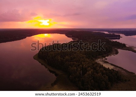 Beautiful sunset aerial view of lake Galve, one of most popular lakes among water-based tourists, divers and holiday makers, located in Trakai, Lithuania. Royalty-Free Stock Photo #2453632519