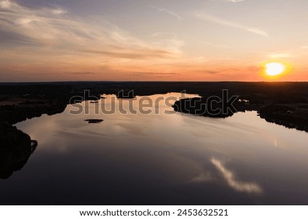 Beautiful sunset aerial view of lake Galve, one of most popular lakes among water-based tourists, divers and holiday makers, located in Trakai, Lithuania. Royalty-Free Stock Photo #2453632521