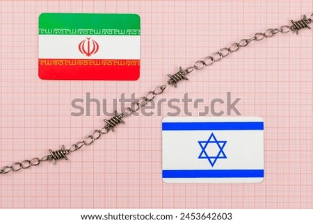 Chain with barbed wire between Iranian and Israeli flags on a background of graph paper. Confrontation between Iran and Israel