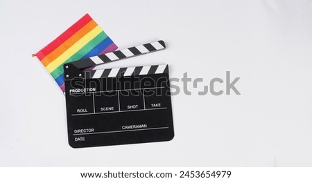 Clapperboard and Rainbow pride flag on white ackground.	

