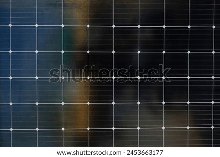 A black and white photo of a solar panel with a grid of white dots. The photo has a moody, somewhat ominous feel to it, as if it is capturing a moment of darkness or uncertainty