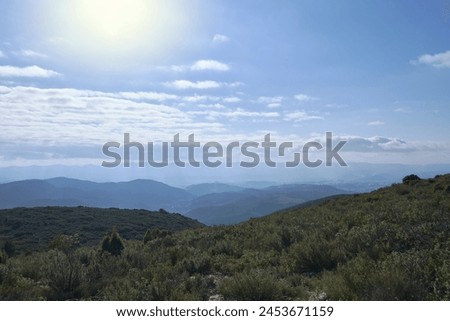 A Mountain landscape with clouds and sunshine. Shrubs, sunbeams through the clouds. No people, empty space, lines, shadows, clarity.