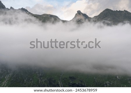 Thick low hanging cloud obstructs the mountains, Hohe Tauern National Park, Osttirol, Austria Royalty-Free Stock Photo #2453678959