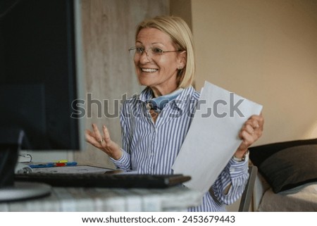 mature blonde woman works online from home and has video consultations