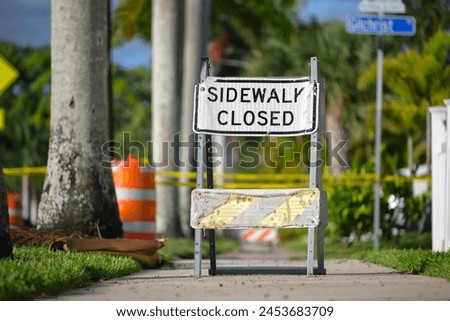 Warning sign that sidewalk is closed at street construction site. Utility work ahead