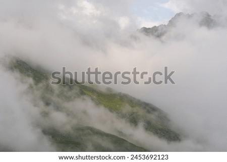 Light piercing through thick fog after the storm, Hohe Tauern National Park, Osttirol, Austria Royalty-Free Stock Photo #2453692123