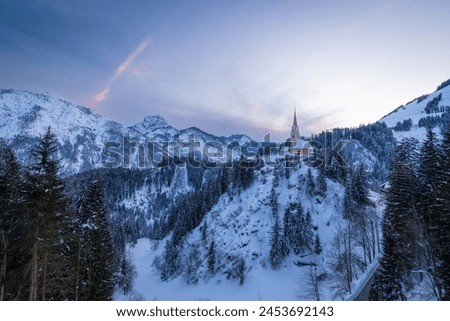 Sankt Justina church during a snowy winter sunset, Pustertal, Assling, Osttirol, Austria Royalty-Free Stock Photo #2453692143