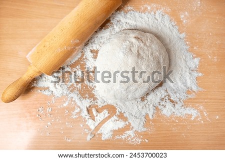 Dough on the table, in the middle of the flour