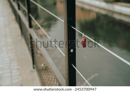 Solitary Red Love Lock on Bridge Railing Royalty-Free Stock Photo #2453700947