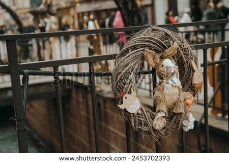 Easter Wreath with Bunny on City Street Railing Royalty-Free Stock Photo #2453702393