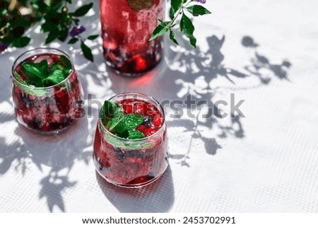 Berry refreshing cold summer drink. Cocktail or mocktail with ripe seasonal berries and mint. Detox drink. Fruit iced thirst quenching drink. Royalty-Free Stock Photo #2453702991