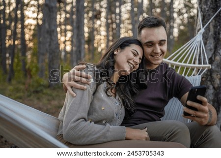 Man and woman young adult couple in nature take self portrait photo selfie ugc use mobile phone smartphone or make a video call