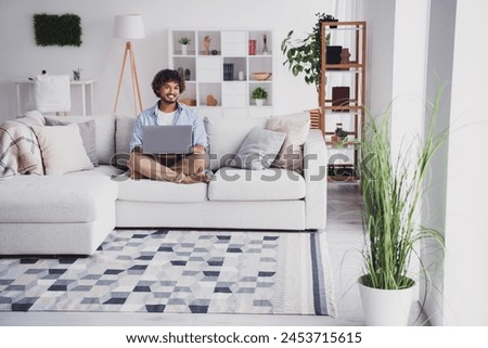 Photo of handsome cheerful guy dressed plaid shirt typing emails modern device indoors room home house