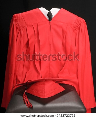 close up of a red high school or college graduation cap and gown  Royalty-Free Stock Photo #2453723739