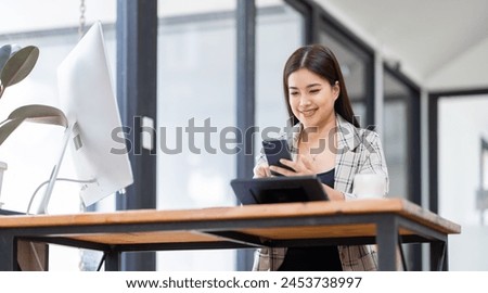 Portrait of young Asian businesswoman in suit, woman smiling and work at workplace inside office, accountant with calculator behind paper phone signing contracts and financial reports	