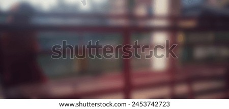 A blurred scene: a crimson booth shrouds a shadowy figure, eerie and still, as if lurking within. Royalty-Free Stock Photo #2453742723