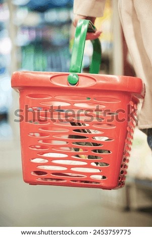 Person, hands and shopping with grocery basket, cart or bucket for food, ingredients or snacks in supermarket. Closeup of customer, consumer or shopper buying stock, supplies or groceries at store